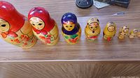 Photo showing all 8 wooden Russian nesting dolls in a row from largest to smallest, highlighting red and yellow painted dolls.