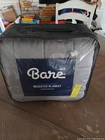 Front view of sealed Bare weighted blanket packaging showing brand label and carrying handle
