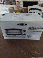 Box of Bella 4-slice toaster oven with product photo and information in Spanish