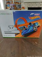 Front of sealed retail box showing console, controller and track artwork