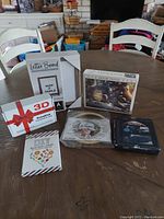 Wide shot of all items on wooden table including letter board, puzzle box, 3D lamp box, DIY cards, and needle point kit.