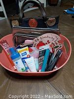 Photo showing entire lot in a pink plastic container with two makeup bags and assorted makeup and skincare items.