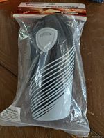 Front view of DashSport Strikers Soccer Shin Guards in original clear packaging, showing the black and white design and logo shield.