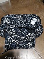 Purse and overnight bag together displaying the black and white floral pattern.