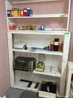 Wide view of shelves displaying all appliances and thermoses with bathroom scales below.