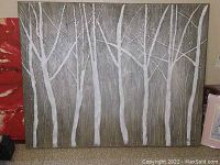 Front view showing large rectangular painting of a white forest with tree trunks and branches on gray background.