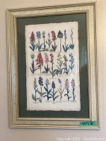 Framed botanical print showing a variety of flowers with green matting and gold textured frame