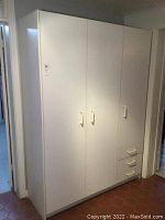 Full frontal view of the white melamine storage unit showing three closed doors and three drawers at bottom right.