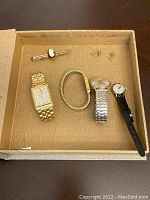Overview of all watches, bracelet, earrings, and Woolno tie clip in box.