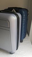 Two carry-on suitcases, one silver and one blue, shown from side angle.