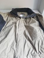 Full view of men's beige Columbia jacket XL laid flat, showing front with zipper and flap closure.
