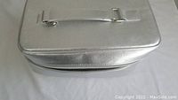 Silver textured zippered makeup bag with handle, empty inside