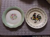Photo of front of decorative plates showing floral and rooster designs on 10-inch ceramic plates