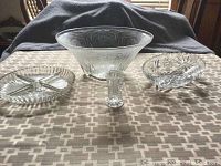 Front view of entire set showing large bowl, two divided dishes, and small toothpick holder on a patterned cloth surface.