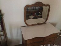 Front angle view of wooden desk with attached mirror showcasing linoleum top and drawer arrangement