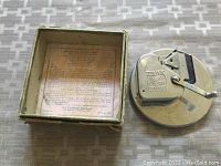 Photo showing razor blade sharpener next to original box with text inside box