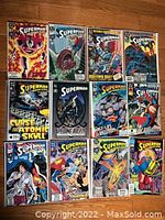 Twelve Superman comic books laid out showing front covers with various dynamic covers and titles in visible condition.