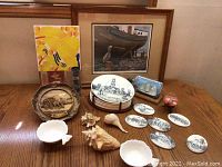 Image showing all items arranged on a wooden table, including framed art and nautical collectibles.