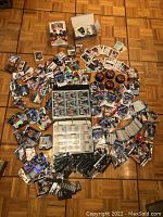 Full lot view showing hockey cards spread out on floor including binders, loose cards, mini-pucks, and card packs.