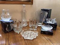 Overview photo of the entire collection arranged on wood table showing multiple crystal pieces with boxes