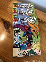 Three copies of The Amazing Spider-Man Double Trouble Vol 1 No 2 comic book stacked on a wooden surface, showing full front covers with colorful artwork depicting Spider-Man and other characters.