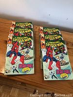 Multiple copies of The Amazing Spider-Man Vol 1 No. 5 comic books stacked on a wooden surface, showing the front cover titled 'Dead Ball'.