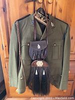 Jacket, sporran and pouch hung on hanger
