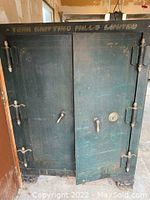 Front view of the vintage safe with the left door fully shut and right door partially open, showing the 'YORK KNITTING MILLS LIMITED' gold lettering at top.