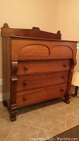 Front view of antique wooden bonnet chest with four drawers, showing top bonnet section with overhang pull and three lower drawers with wood knobs.