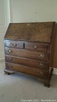 Front view of Ethan Allen wooden secretary desk with slant front closed.