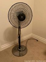 Front view of the black metal oscillating floor fan with Weatherworks logo on center panel.