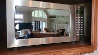 Front view of Panasonic stainless steel inverter microwave oven with mirrored door and control panel.