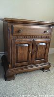 Full view of Ethan Allen night stand showing drawer and cabinet doors, wood grain, and finish.