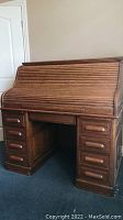 Front view of oak rolltop desk with tambour closed and drawers visible