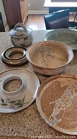 Full view of the pottery pieces on countertop showing large bowls, covered dish with lid, rings, and tray.
