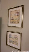 Two framed watercolor paintings hanging on wall, showing the farm and field scenes.