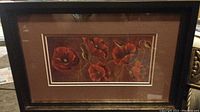 Front view of the painting showing vibrant red poppies in a rectangular wooden frame painted black with gold trim and double ivory matting.