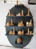 Full view of the display shelf with all 12 miniature shore light figurines arranged on it.