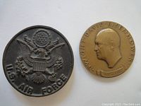 Photo showing both sides of the two medallions: U.S. Air Force emblem and Eisenhower profile