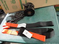 Full view of chain hoist with long steel chain and two new black lifting straps with orange loops