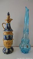 Photo showing James Beam decanter and Kanawha blue vase side by side for size comparison and detail.