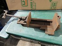 Full view of the heavy-duty metal machine shop vise showing the handle and body with noticeable surface rust and wear.