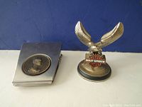 Metal paper clip holder with bronze-toned profile medallion and base metal Harley-Davidson eagle pocket watch stand