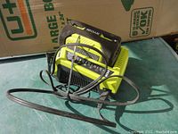 Ryobi 40V Lithium-Ion battery on charger, charger plugged in