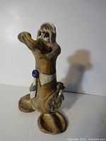 Side angle view showing the ceramic Donald Duck figurine's profile, tall stance and paint detail.