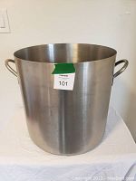 Front view of a large stainless steel stock pot with two handles and a MaxSold label.