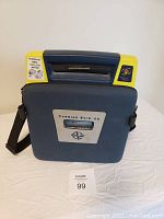Front view of the closed AED in its molded plastic carrying case showing handle and front branding