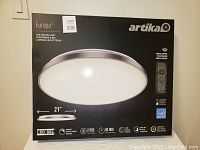 Front view of boxed Artika Europa 21-inch LED flush mount ceiling light showing brand, model, and features on box.