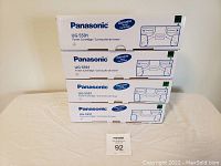 Four stacked Panasonic UG-5591 toner cartridge boxes with a lot number card.