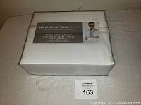 Front packed view of Gluckstein Home 4 Piece Queen Sheet Set in white taupe color, showing packaging label